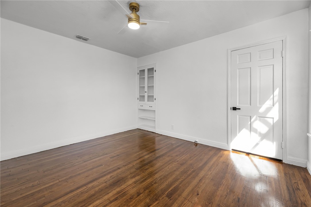 1012 East Main Street Sinton, TX 78387 - Photo 25 of 34 an empty room with wooden floor and windows