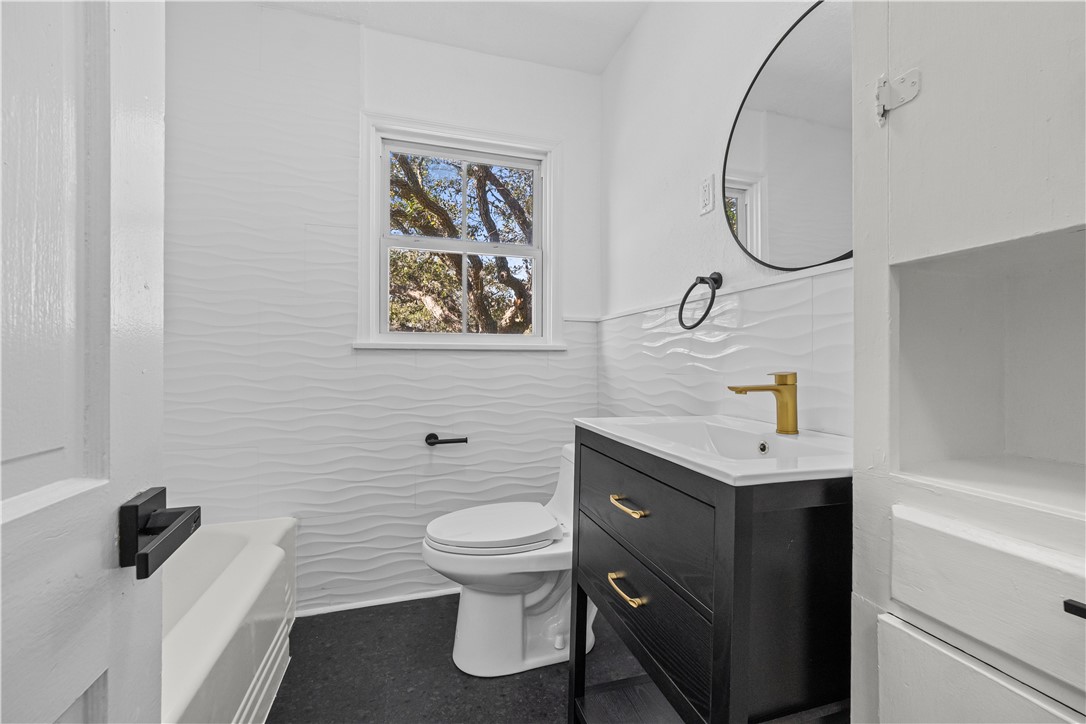 1012 East Main Street Sinton, TX 78387 - Photo 27 of 34 a bathroom with a toilet sink and mirror