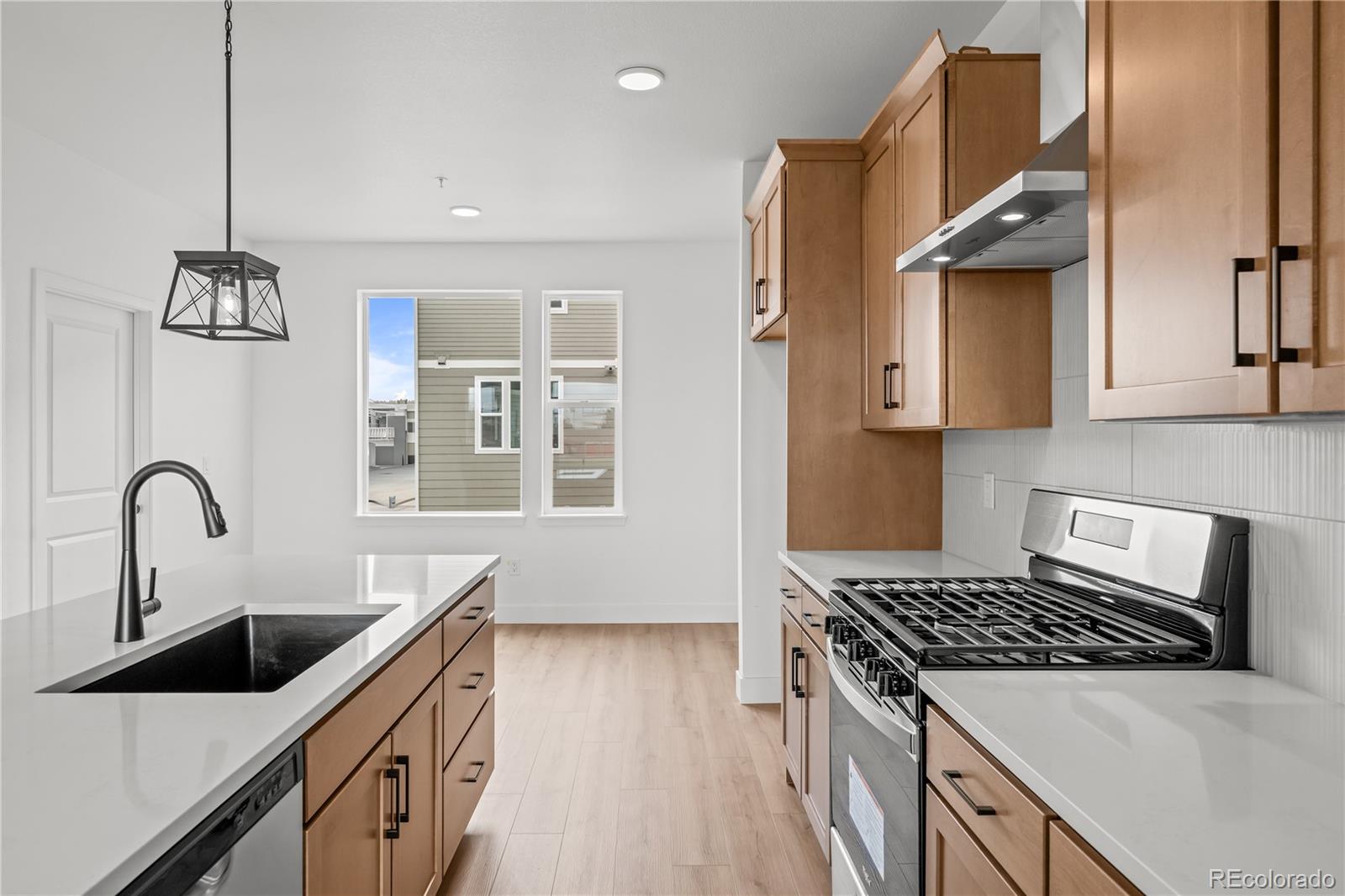 2736 West 68th Avenue Denver, CO 80221 - Photo 1 of 44 a kitchen with stainless steel appliances a sink a stove and a wooden floors
