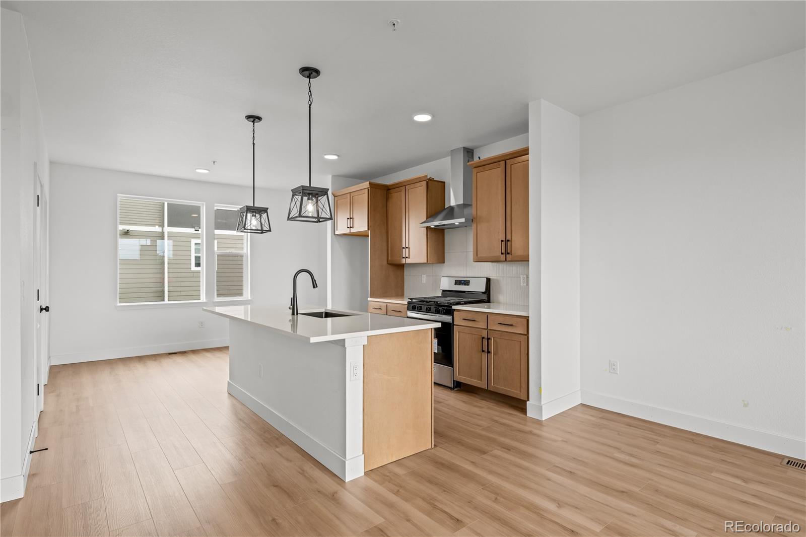 2736 West 68th Avenue Denver, CO 80221 - Photo 13 of 44 a kitchen with stainless steel appliances granite countertop a stove a sink and a refrigerator