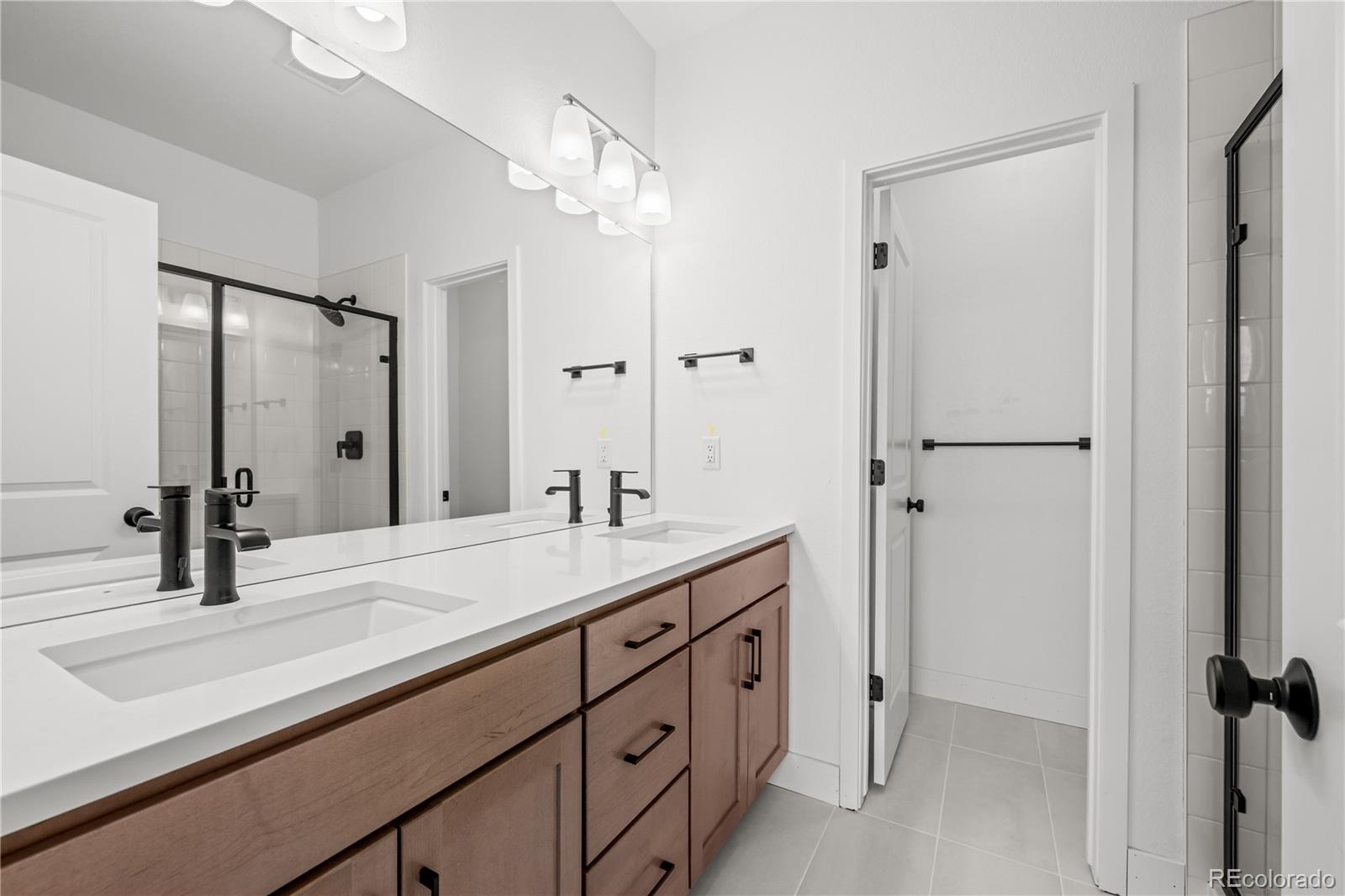 2736 West 68th Avenue Denver, CO 80221 - Photo 27 of 44 a bathroom with a double vanity sink mirror and double