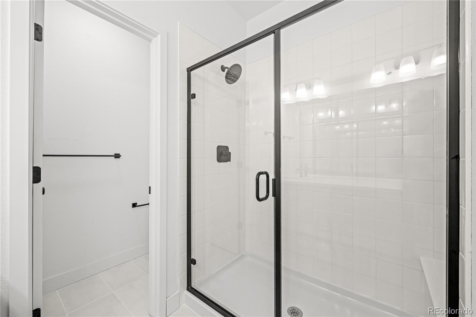 2736 West 68th Avenue Denver, CO 80221 - Photo 28 of 44 a bathroom with a glass shower door