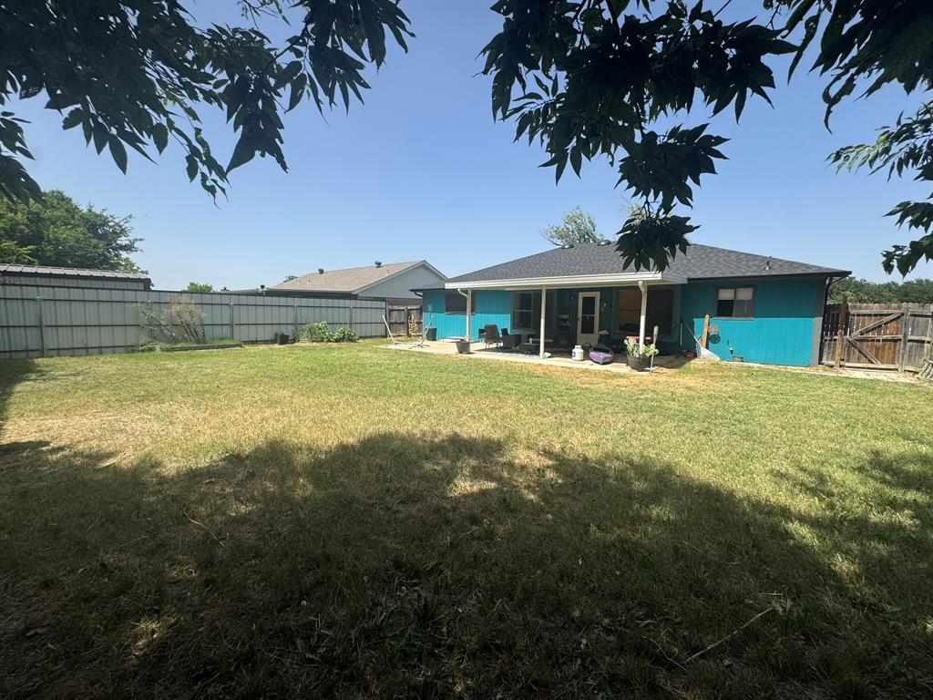 812 Reveille Road Fort Worth, TX 76108 - Photo 21 of 22 Spacious backyard featuring a covered patio, solid fencing, and mature trees
