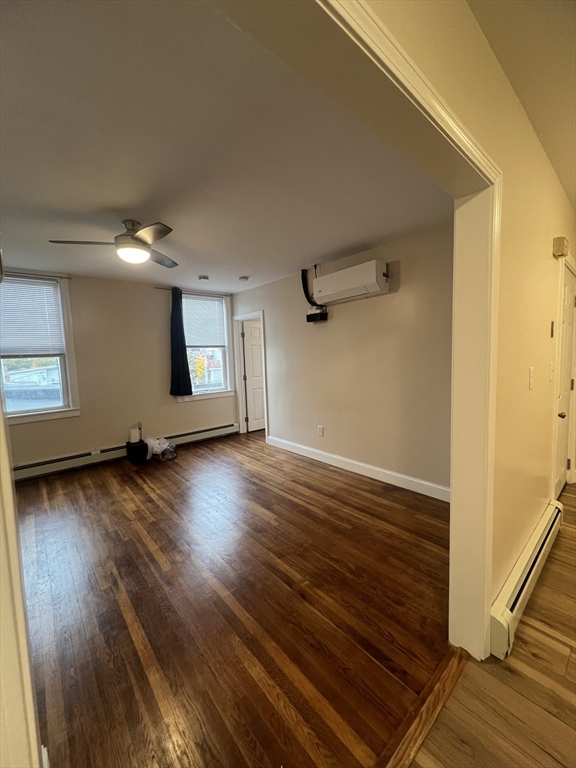 13 Perkins Avenue, Unit 1 Brockton, MA 02301 - Photo 4 of 5 an empty room with wooden floor and windows