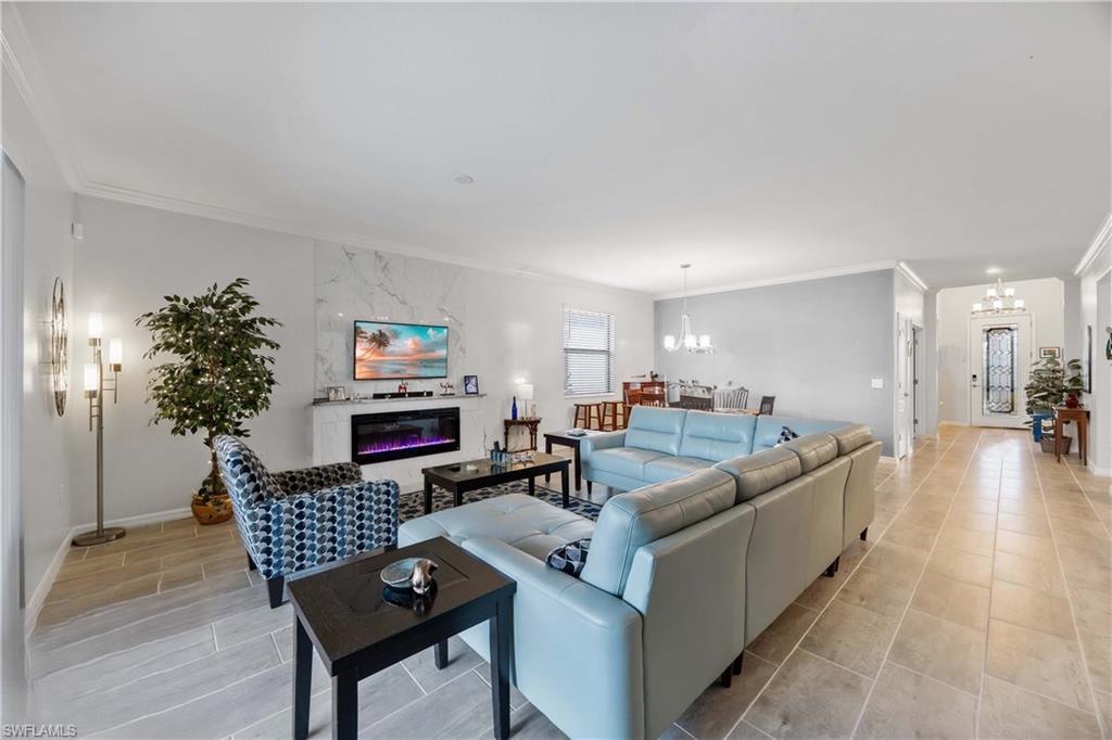 1602 Santiago Circle Naples, FL 34113 - Photo 11 of 49 Living room with ornamental molding, hanging lights, and a premium fireplace