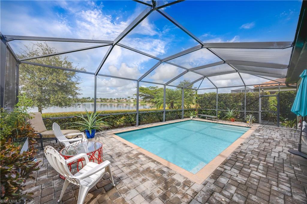 1602 Santiago Circle Naples, FL 34113 - Photo 28 of 49 Swimming pool featuring a sunroom, a patio area, a water view, and a lanai