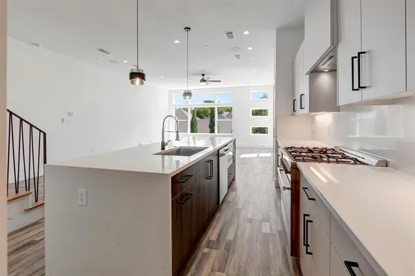 a kitchen with stainless steel appliances a sink stove and cabinets