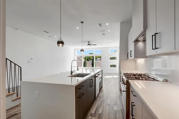 a kitchen with stainless steel appliances a sink stove and cabinets