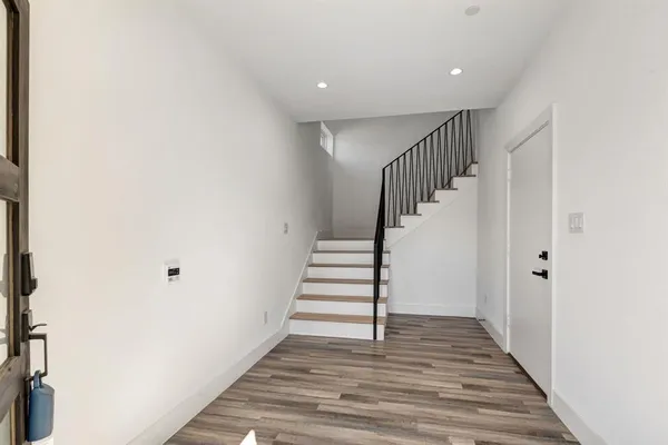 a view of a hallway with wooden floor and entryway