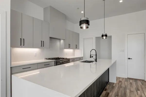 a kitchen with stainless steel appliances a sink a stove and a wooden floors