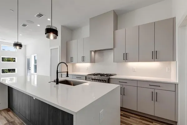 a kitchen with a sink a stove and cabinets