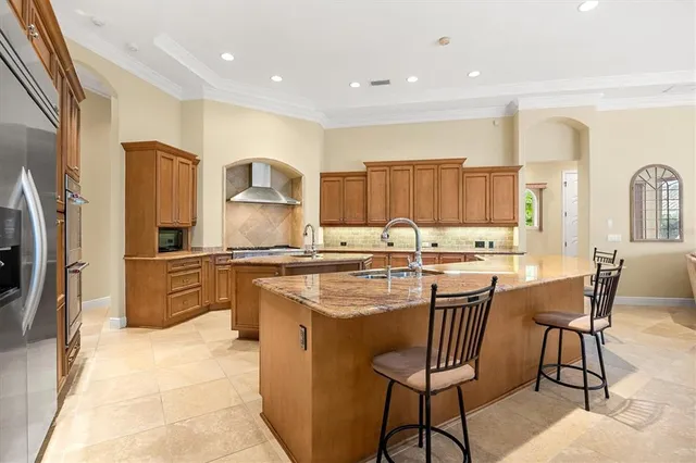a kitchen with stainless steel appliances granite countertop a sink and a refrigerator