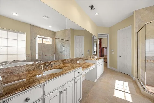 a large bathroom with a granite countertop sink mirror and a bath tub