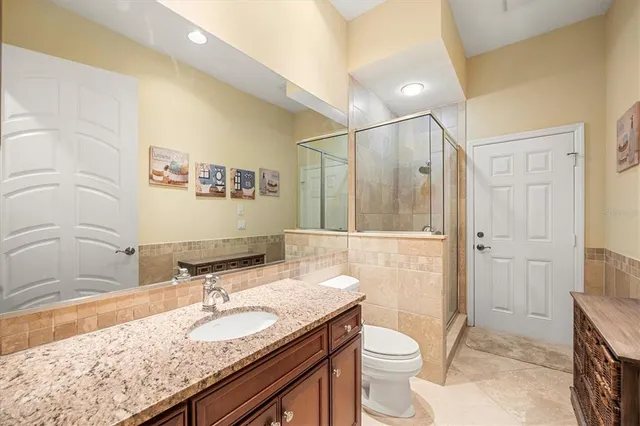 a bathroom with a granite countertop sink toilet and shower