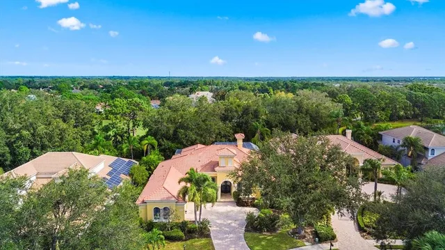 an aerial view of a house with a yard and lake view