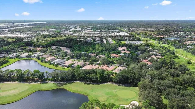 an aerial view of residential houses with outdoor space and trees