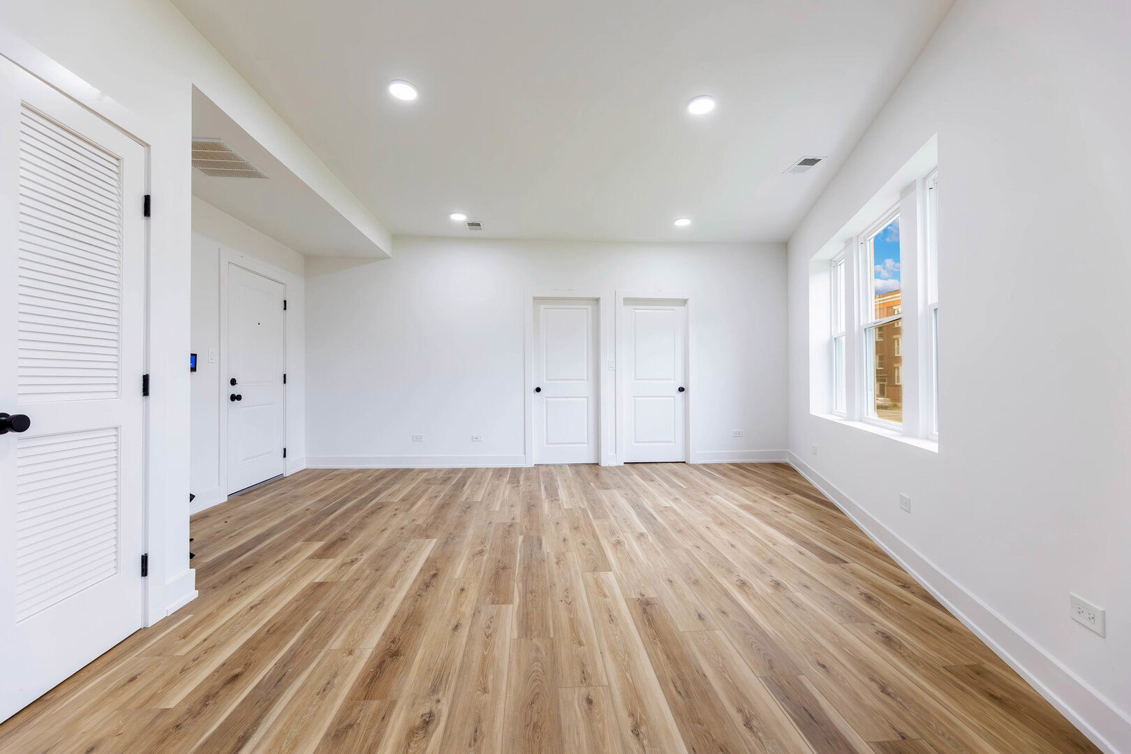 243 West 74th Street, Unit 2 Chicago, IL 60621 - Photo 6 of 12 a view of an empty room with wooden floor and a window