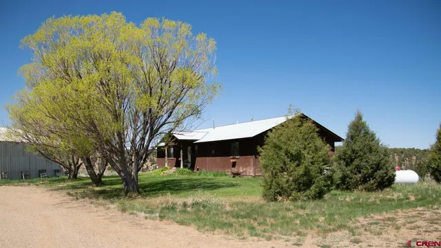 a view of a house with a tree and a yard