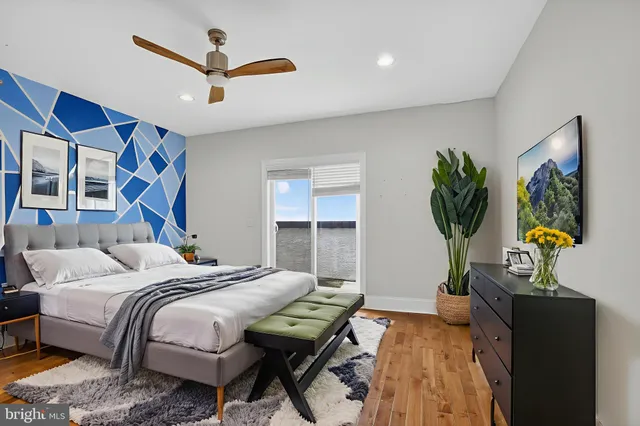 a bedroom with a bed a couch and a potted plant