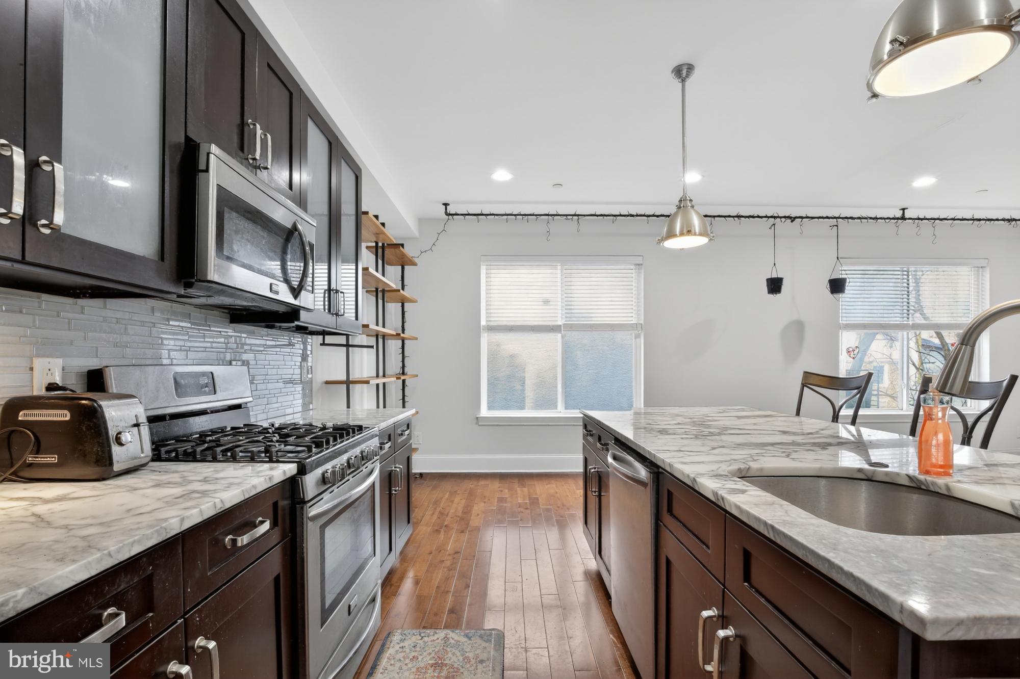 946 North 2nd Street, Unit 5 Philadelphia, PA 19123 - Photo 6 of 31 a kitchen with stainless steel appliances granite countertop a sink a stove and a wooden floors