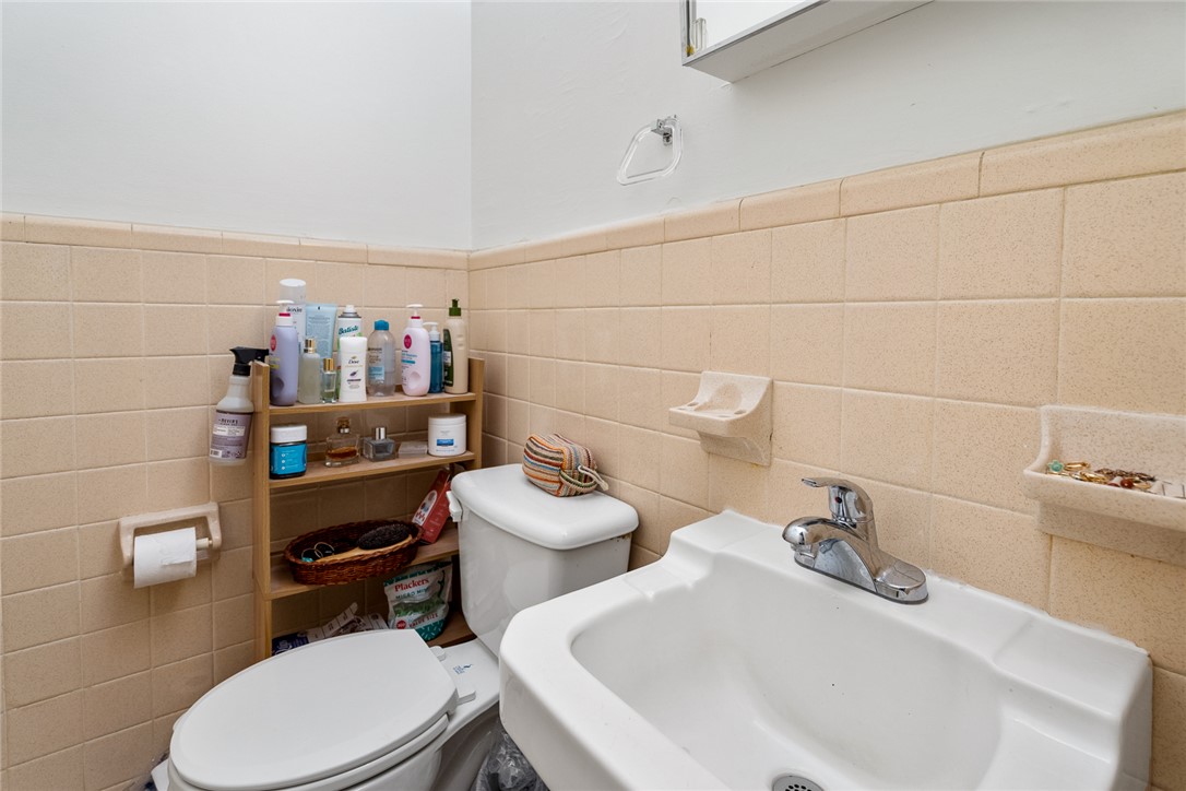 308 Clayton Street Central, SC 29630 - Photo 18 of 31 This bathroom features practical tile walls and a clean, functional sink with a commode.
