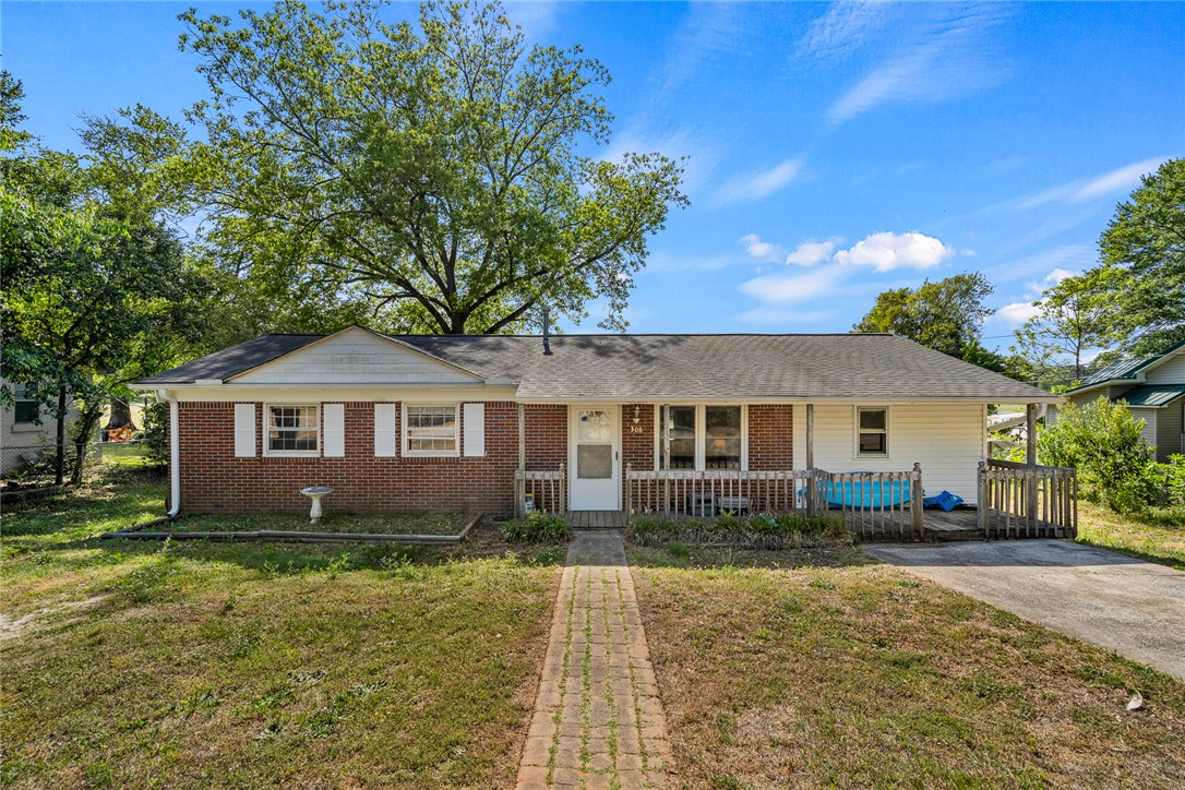 308 Clayton Street Central, SC 29630 - Photo 4 of 31 This charming residence features a classic facade with brick and siding, a welcoming porch, and a lush front yard.