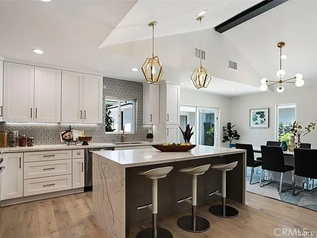 a kitchen with stainless steel appliances a stove a sink a refrigerator and a refrigerator