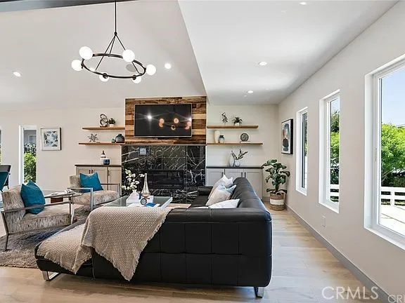 a living room with furniture a fireplace and a flat screen tv