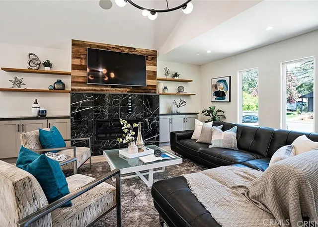 a living room with furniture a flat screen tv and a fireplace