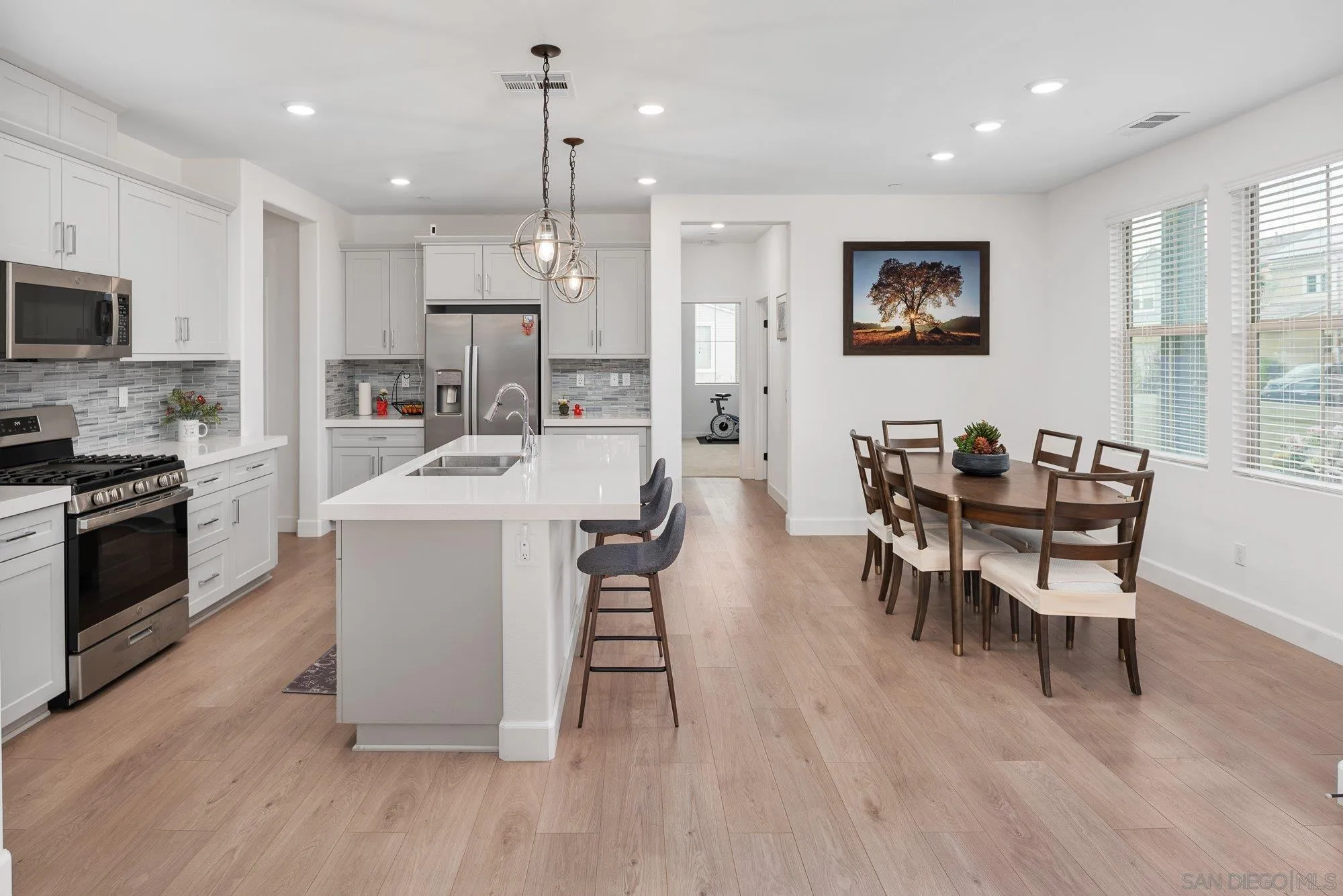1091 Barry Place Escondido, CA 92026 - Photo 2 of 40 a dining room with furniture a wooden floor and a sink