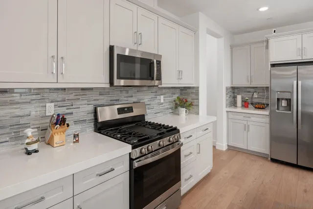 a kitchen with cabinets stainless steel appliances and a sink