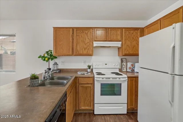 a kitchen with a stove a refrigerator and a sink