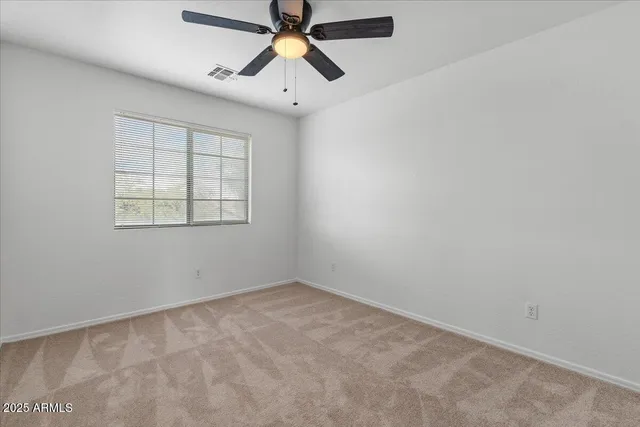 an empty room with chandelier fan
