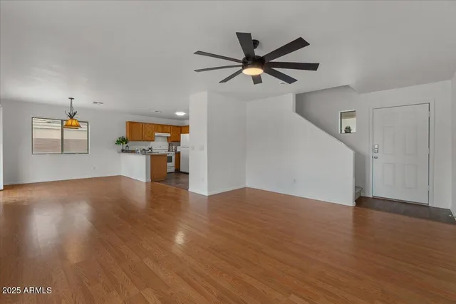 a view of empty room with wooden floor and window