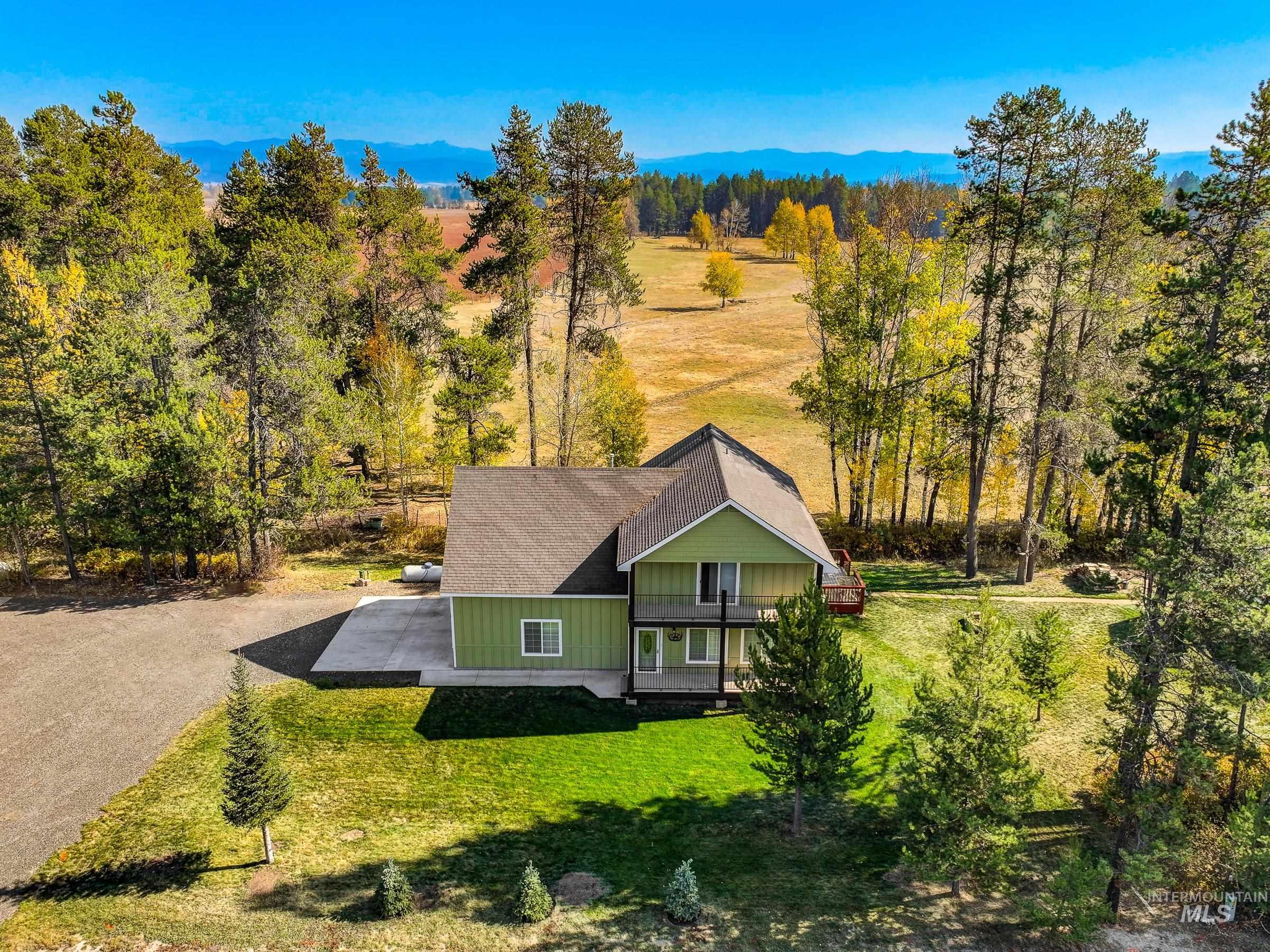 Aerial view of property and surrounding area featuring a mountain backdrop