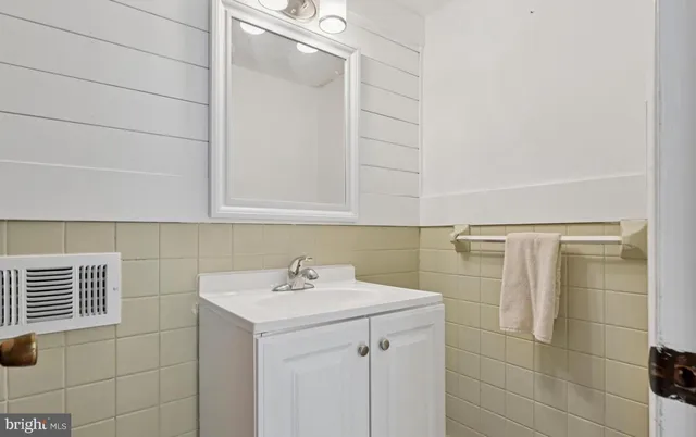 a bathroom with a sink shower and a mirror
