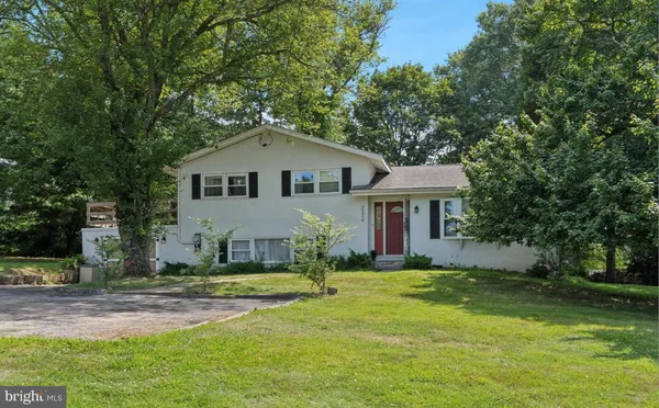 a front view of a house with a garden and trees