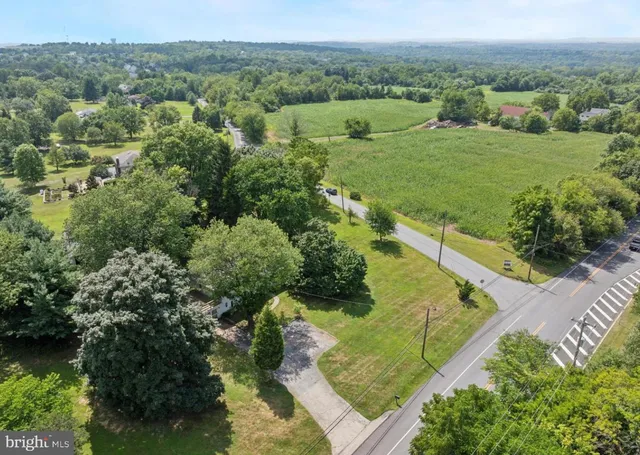 an aerial view of green landscape with trees houses and mountain view