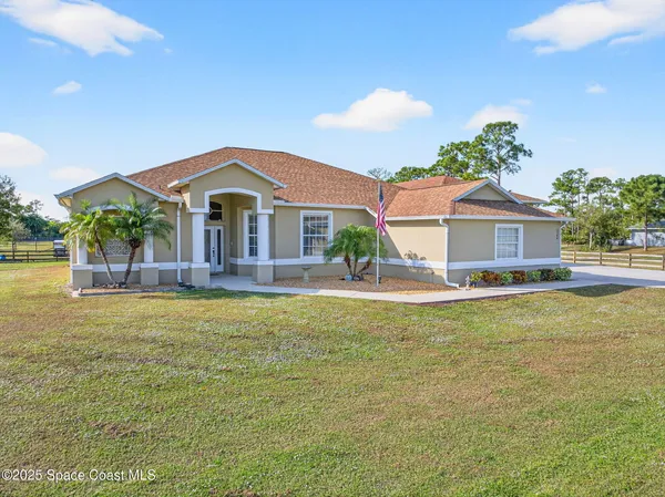a front view of a house with a garden