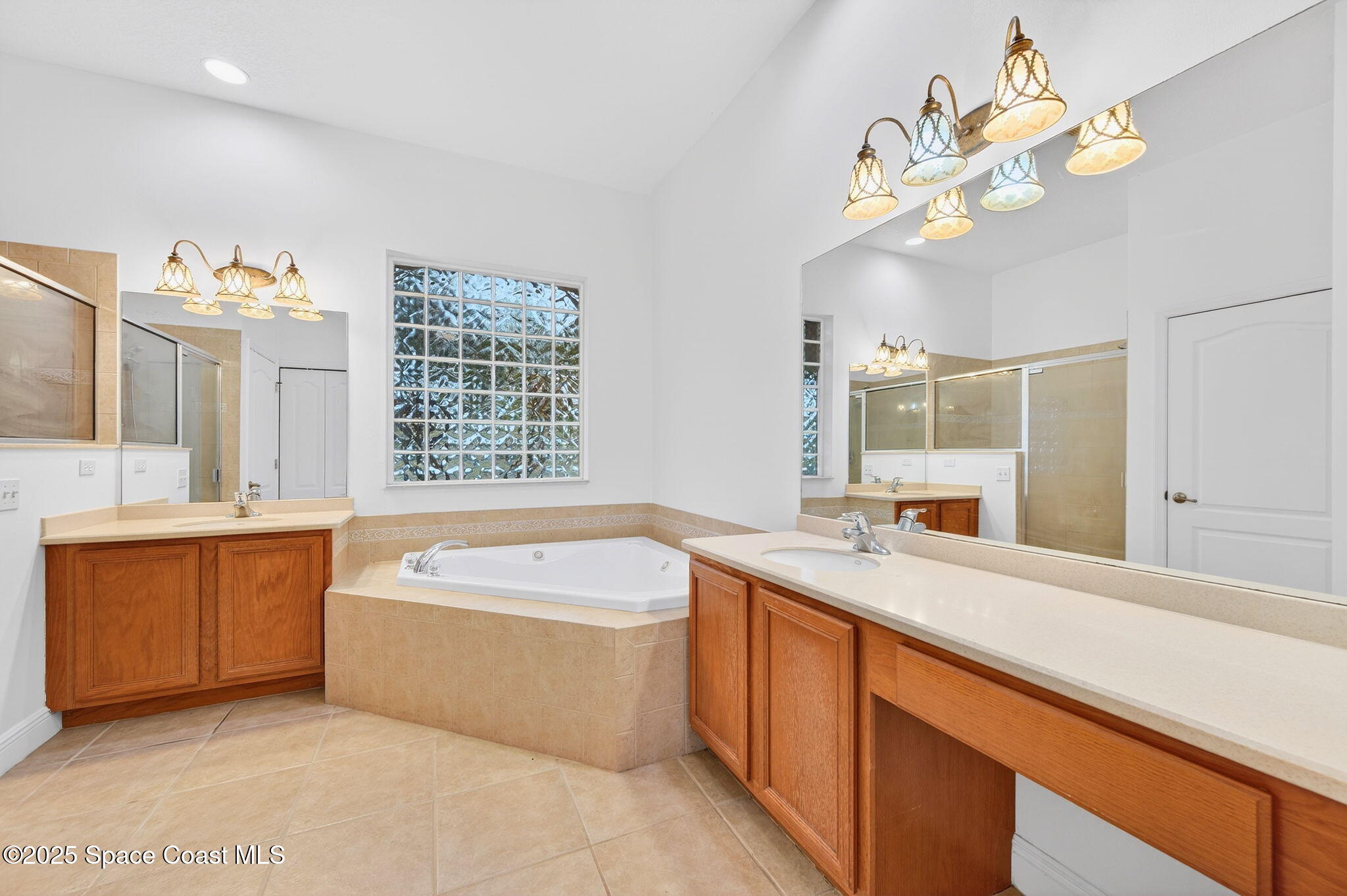 2740 Waring Lane Malabar, FL 32950 - Photo 69 of 98 a bathroom with a tub a sink double vanity and a mirror