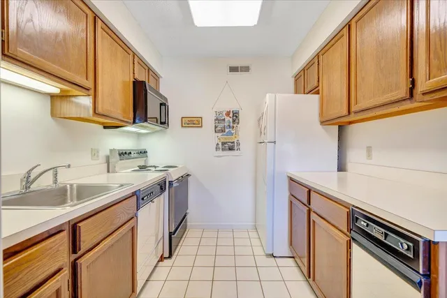 a kitchen with stainless steel appliances granite countertop a refrigerator and a sink