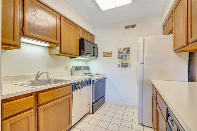 a kitchen with stainless steel appliances granite countertop a refrigerator sink and stove