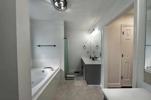 a bathroom with a tub shower and sink