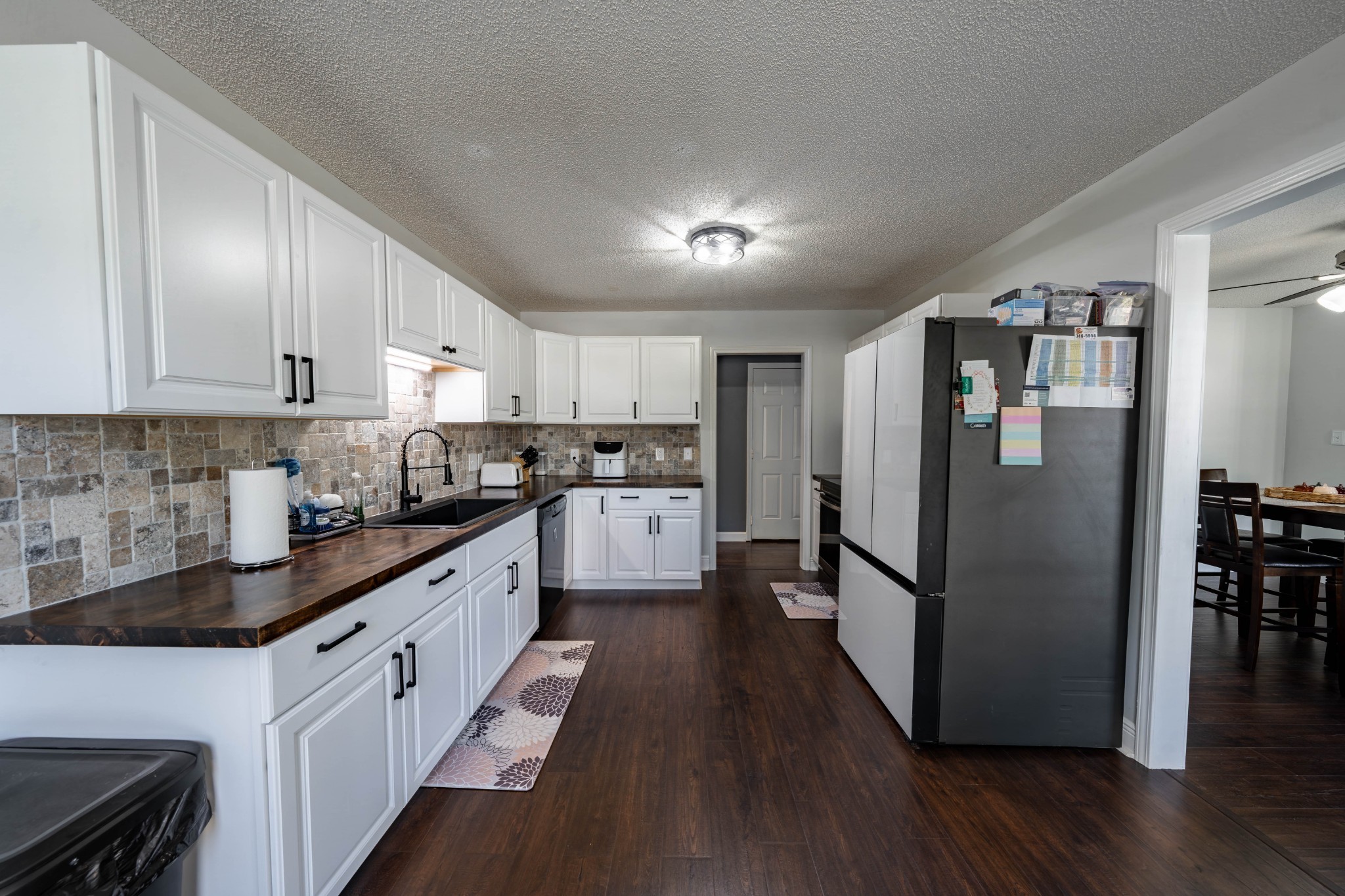 1101 Rustling Oaks Drive Pleasant View, TN 37146 - Photo 13 of 19 a kitchen with stainless steel appliances granite countertop a refrigerator a sink dishwasher a stove and white cabinets with wooden floor