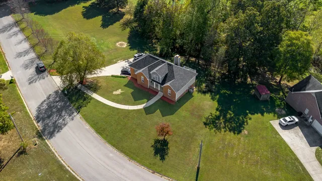 an aerial view of a house with a garden and trees