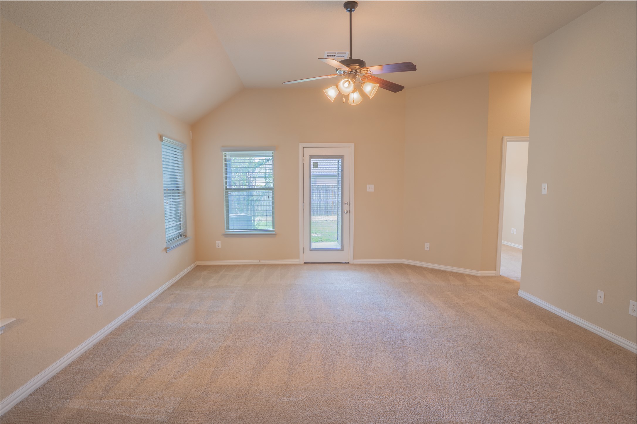 403 Tascate Street Georgetown, TX 78628 - Photo 8 of 26 A spacious living area with vaulted ceilings and outdoor access beckons relaxation.
