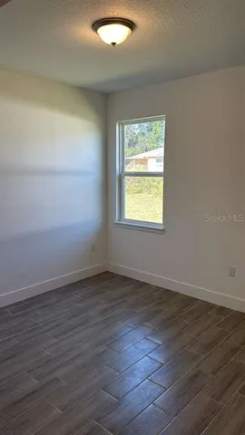 an empty room with wooden floor and a window