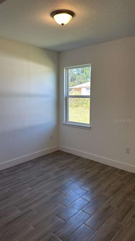 2827 Southwest 137th Lane Ocala, FL 34473 - Photo 7 of 11 an empty room with wooden floor and a window