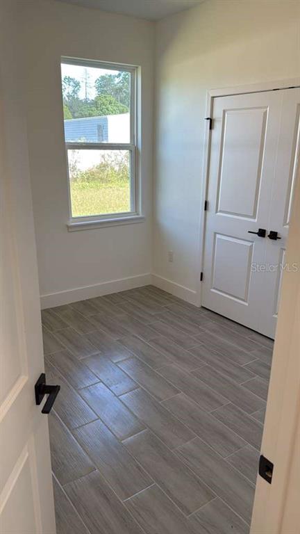 2827 Southwest 137th Lane Ocala, FL 34473 - Photo 8 of 11 an empty room with wooden floor and a window