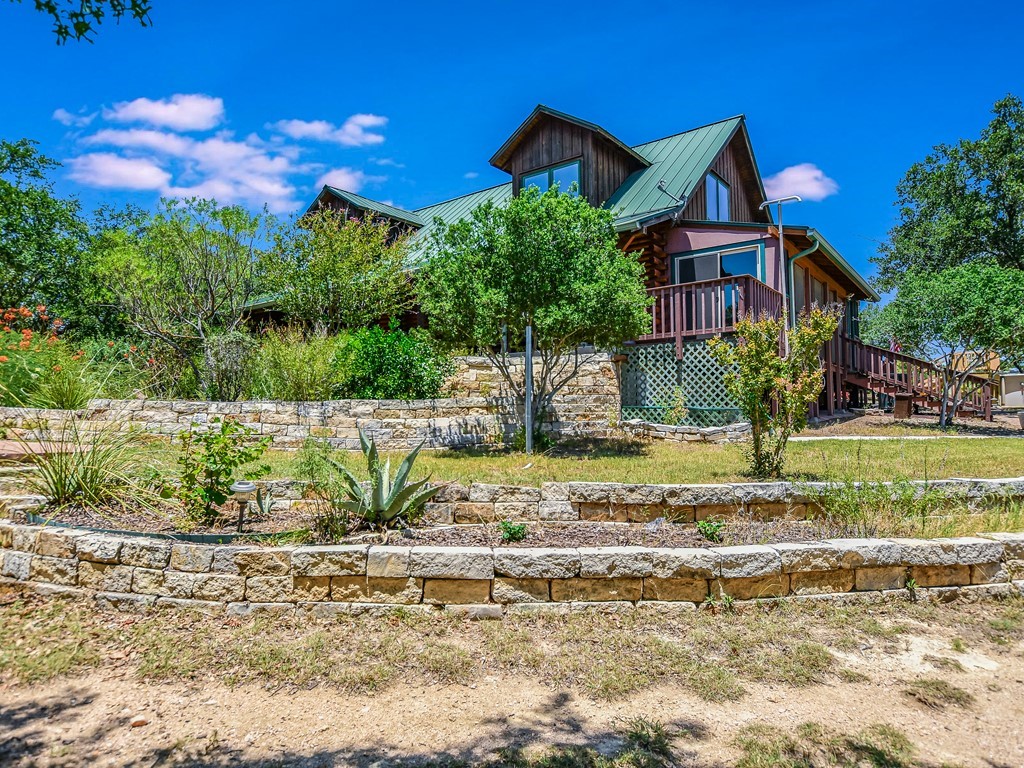 254 Middleton Road Spicewood, TX 78669 - Photo 2 of 32 a front view of a house with garden